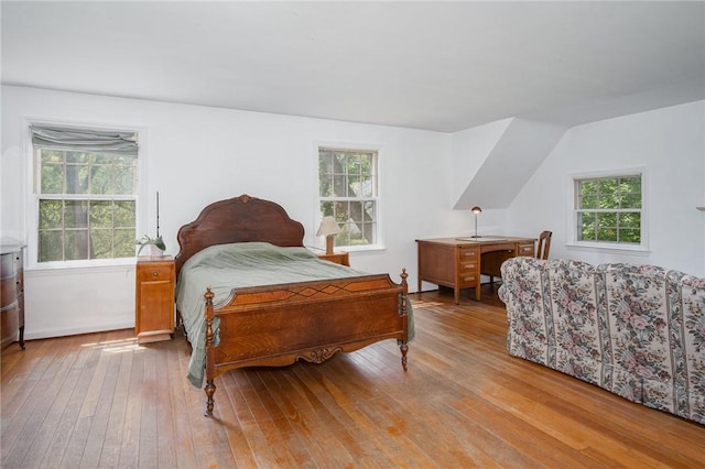 bedroom with hardwood / wood-style floors and multiple windows