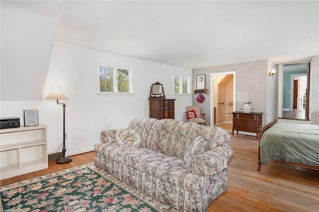 living room with wallpapered walls, light wood-type flooring, and baseboards