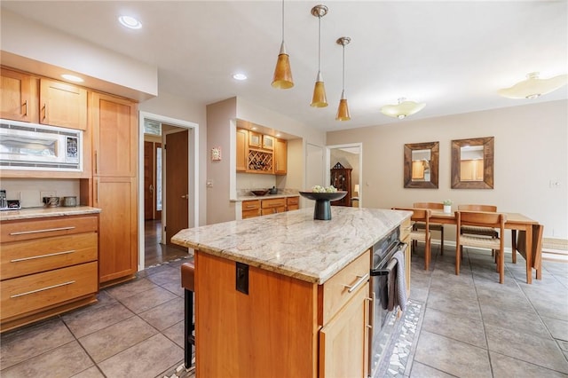 7 Mount View Cres, Penfield, NY 14580 - kitchen featuring stainless steel microwave, a kitchen island, light stone counters, light tile patterned floors, and pendant lighting