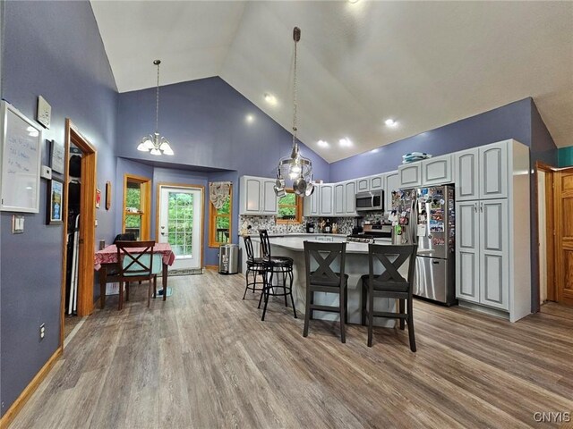437 Nye Rd, Virgil, NY 13045 - kitchen featuring stainless steel appliances, high vaulted ceiling, a chandelier, a center island, and wood finished floors