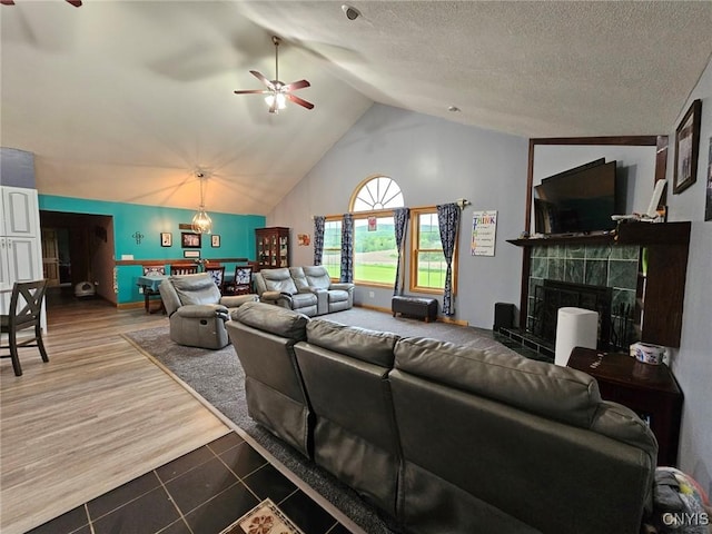 437 Nye Rd, Virgil, NY 13045 - living area featuring ceiling fan, a tiled fireplace, tile patterned floors, and high vaulted ceiling