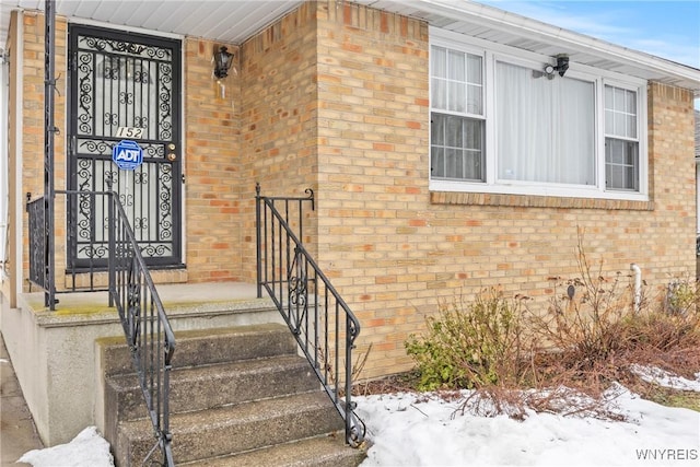 152 Nicholson St, Buffalo, NY 14216 - snow covered property entrance featuring brick siding