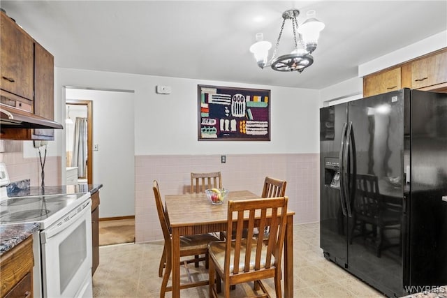 152 Nicholson St, Buffalo, NY 14216 - dining space with a chandelier, tile walls, and a wainscoted wall