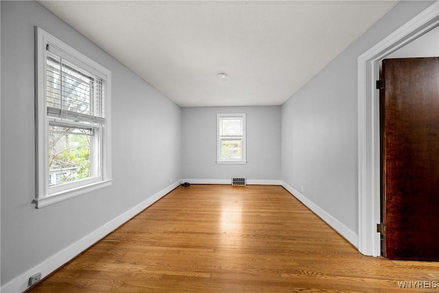 spare room with wood finished floors and baseboards