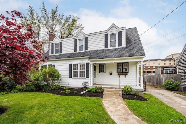view of front of house featuring covered porch, a shingled roof, a chimney, and central AC