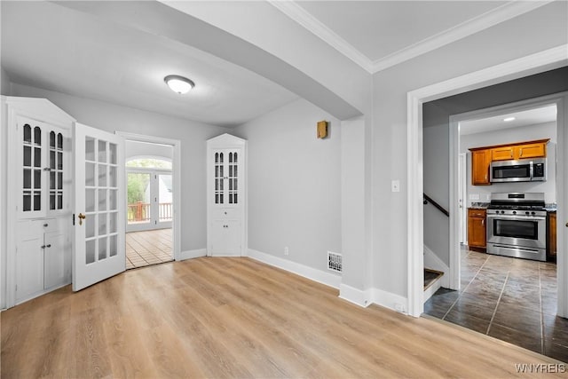 unfurnished dining area with baseboards, crown molding, stairs, and wood finished floors