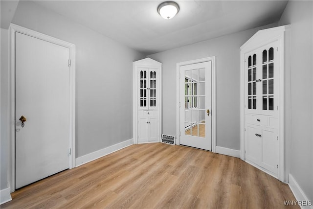 unfurnished dining area with wood finished floors and baseboards