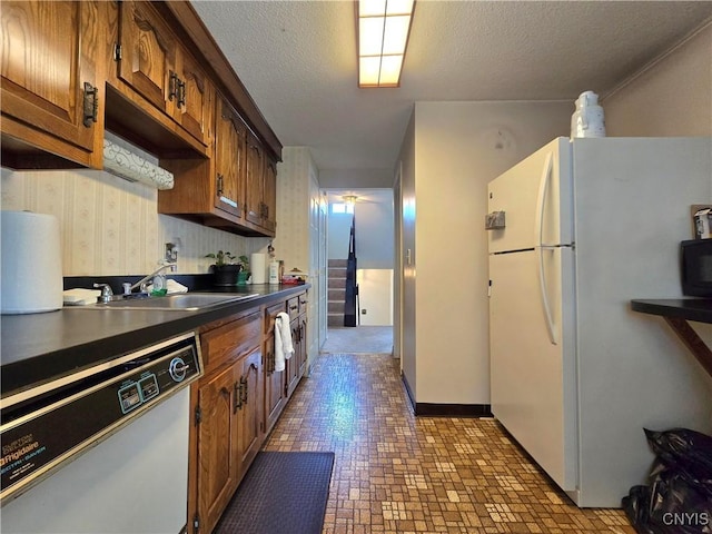332 Cameco Cir, Salina, NY 13090 - kitchen with dishwasher, freestanding refrigerator, a sink, dark countertops, and brick patterned flooring