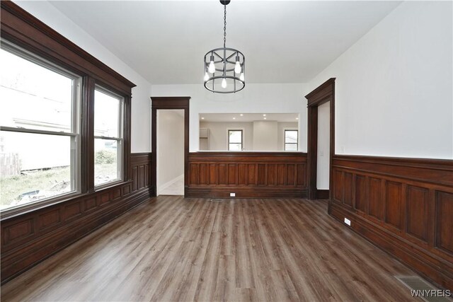 249 E St, Buffalo, NY 14207 - empty room with a wainscoted wall, wood finished floors, and a chandelier