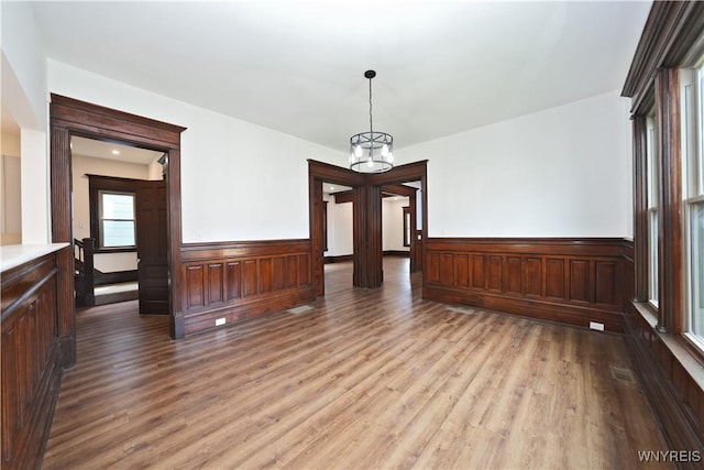 249 E St, Buffalo, NY 14207 - unfurnished dining area featuring wood finished floors, a wainscoted wall, and a chandelier