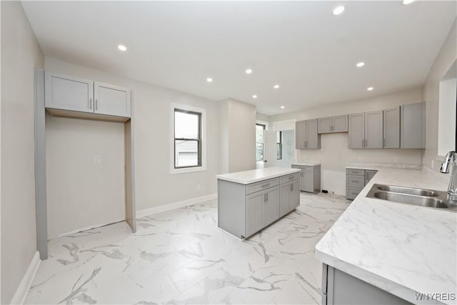 249 E St, Buffalo, NY 14207 - kitchen with gray cabinetry, a sink, baseboards, recessed lighting, and light marble finish floors