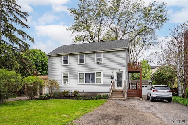 colonial home with a front yard and asphalt driveway