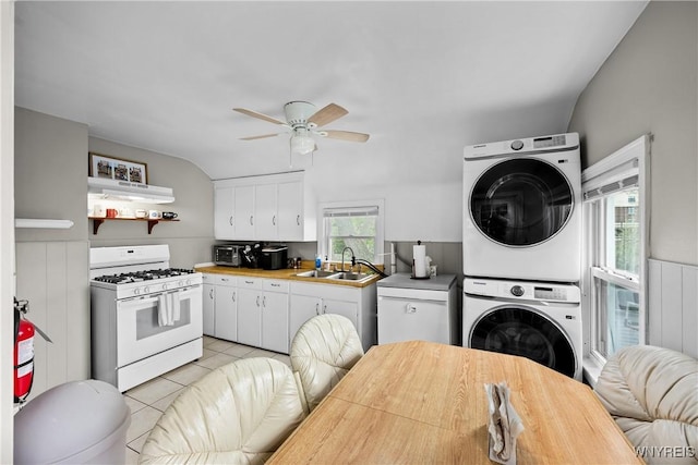 kitchen featuring stacked washer and clothes dryer, white range with gas stovetop, a sink, extractor fan, and a ceiling fan