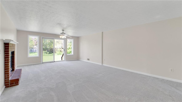 85 Kalyna Dr, Irondequoit, NY 14617 - unfurnished living room featuring baseboards, a ceiling fan, a brick fireplace, carpet floors, and a textured ceiling