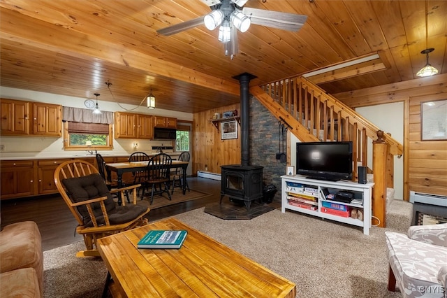 143 Thibado Rd, Webb, NY 13331 - living area featuring a baseboard heating unit, a wood stove, wood ceiling, wood walls, and ceiling fan