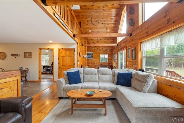 301 Silverstone Rd, Russia, NY 13438 - living area with high vaulted ceiling, wooden walls, baseboards, and wood finished floors