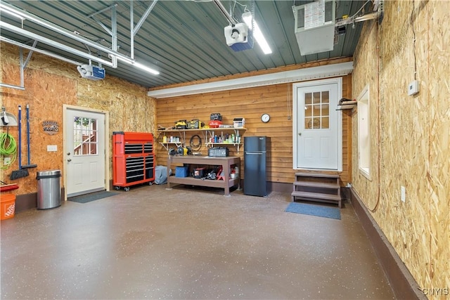 301 Silverstone Rd, Russia, NY 13438 - garage with freestanding refrigerator, a garage door opener, and a workshop area