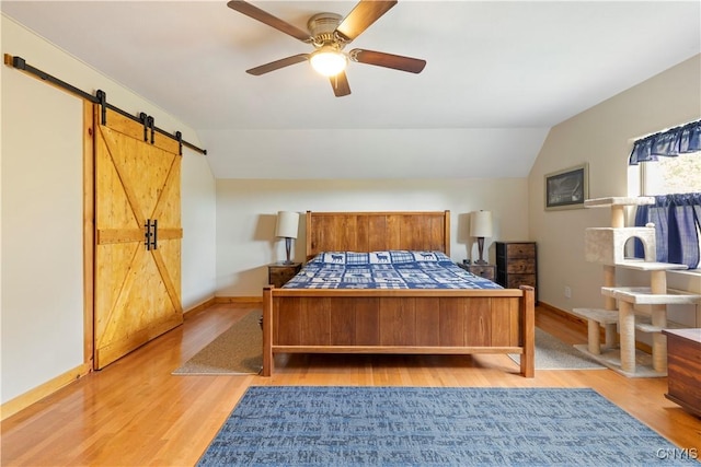 301 Silverstone Rd, Russia, NY 13438 - bedroom featuring a barn door, light wood finished floors, vaulted ceiling, baseboards, and a ceiling fan