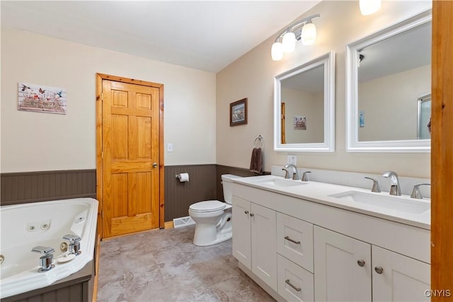 301 Silverstone Rd, Russia, NY 13438 - bathroom featuring wainscoting, a jetted tub, toilet, double vanity, and wooden walls