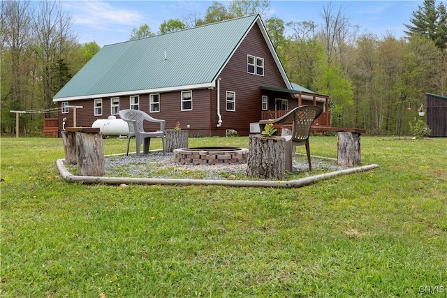301 Silverstone Rd, Russia, NY 13438 - back of property with an outdoor fire pit, a lawn, metal roof, and a deck