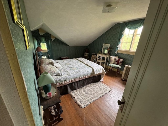 3645 County Highway 12, Kortright, NY 13739 - bedroom with wallpapered walls, radiator heating unit, wood-type flooring, and lofted ceiling