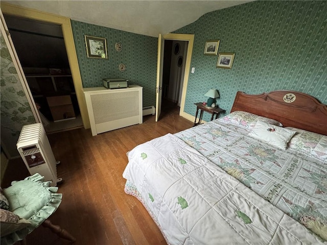3645 County Highway 12, Kortright, NY 13739 - bedroom with wallpapered walls, wood finished floors, vaulted ceiling, a baseboard heating unit, and heating unit
