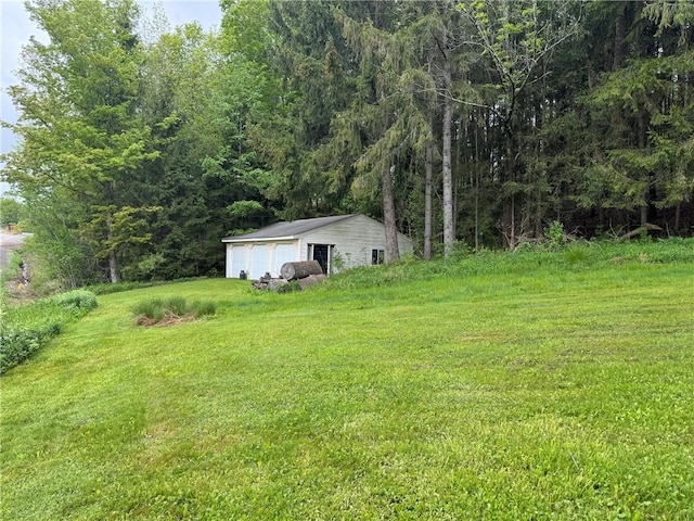 3645 County Highway 12, Kortright, NY 13739 - view of green lawn featuring a garage, an outdoor structure, and a wooded view