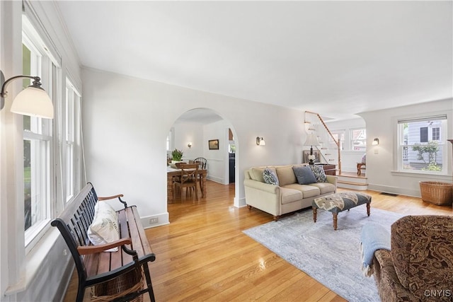 457 Broad St, Oneida-Inside, NY 13421 - living room with stairway, arched walkways, light wood-type flooring, and baseboards