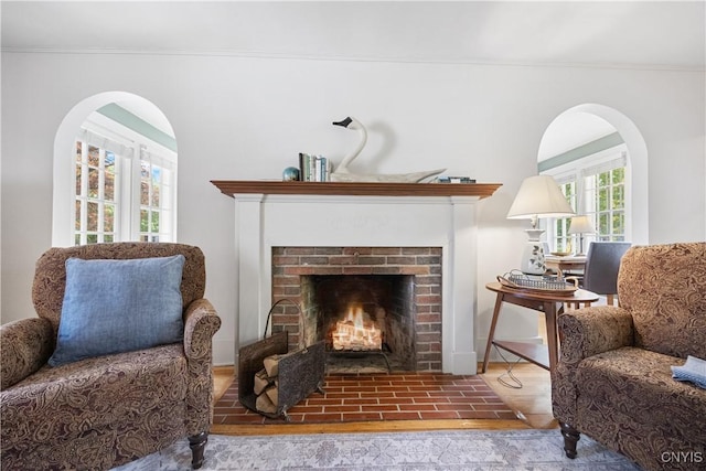 457 Broad St, Oneida-Inside, NY 13421 - sitting room featuring ornamental molding, a brick fireplace, and arched walkways