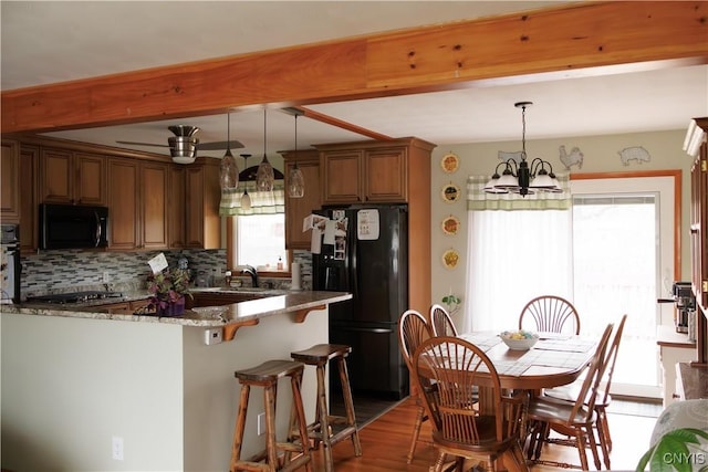 95 Briarcliff Dr, Veteran, NY 14845 - kitchen with black appliances, beam ceiling, dark stone countertops, backsplash, and brown cabinets