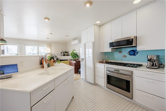 8508 Wickham Blvd, Sodus, NY 14555 - kitchen featuring stainless steel appliances, a wall unit AC, a sink, white cabinets, and light countertops