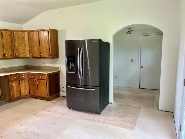 376 Upper Dutch Hill Rd, Milford, NY 13820 - kitchen with black refrigerator with ice dispenser, brown cabinets, arched walkways, vaulted ceiling, and a baseboard heating unit