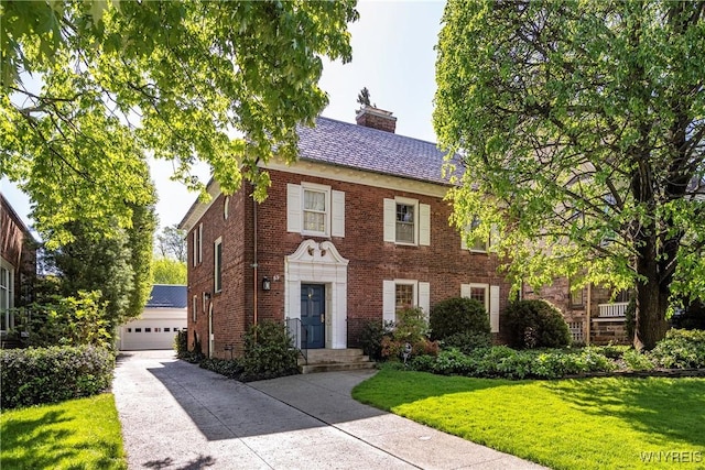 85 Windsor Ave, Buffalo, NY 14209 - view of front of home featuring a chimney, brick siding, a front lawn, an outbuilding, and a garage