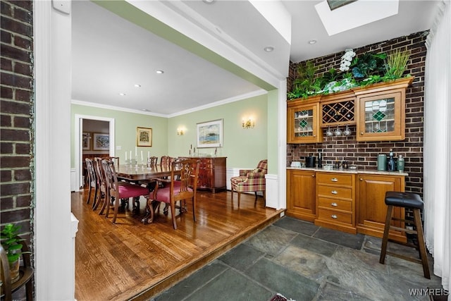 85 Windsor Ave, Buffalo, NY 14209 - dining space featuring crown molding, a skylight, recessed lighting, dark stone finish floors, and bar area