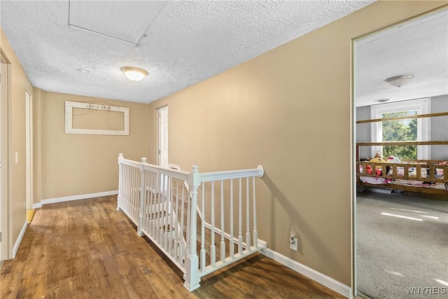 7508 Lakeside Rd, Ontario, NY 14519 - hall featuring an upstairs landing, baseboards, wood finished floors, and a textured ceiling