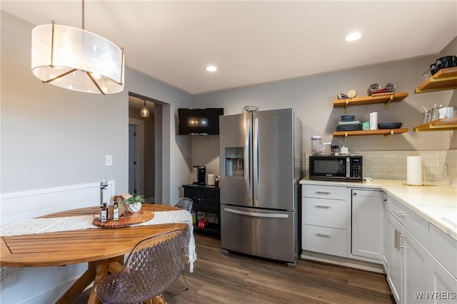 4830 Transit Rd, Cheektowaga, NY 14043 - kitchen featuring stainless steel refrigerator with ice dispenser, black microwave, dark wood-style flooring, white cabinetry, and light stone counters