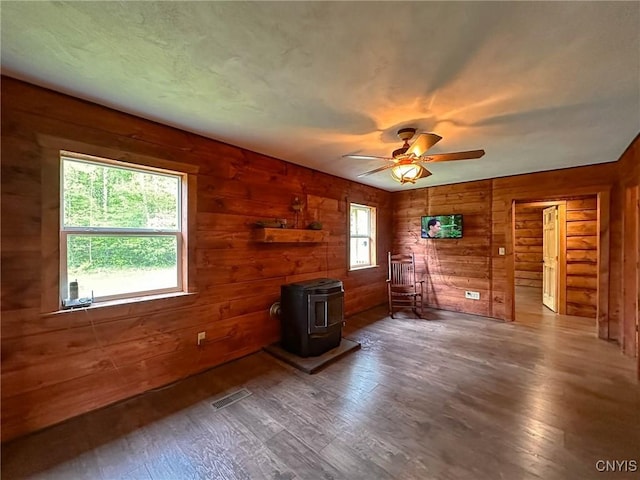 3742 State Route 8, Ohio, NY 13324 - living room with a wood stove, hardwood / wood-style floors, a ceiling fan, and wood walls