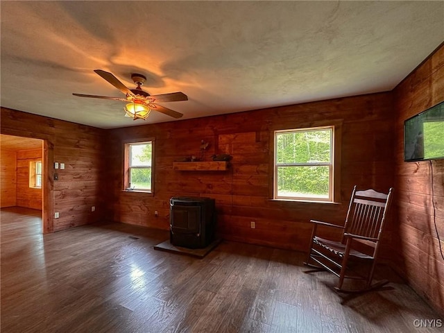 3742 State Route 8, Ohio, NY 13324 - living area with a wood stove, dark wood-style flooring, wooden walls, and ceiling fan