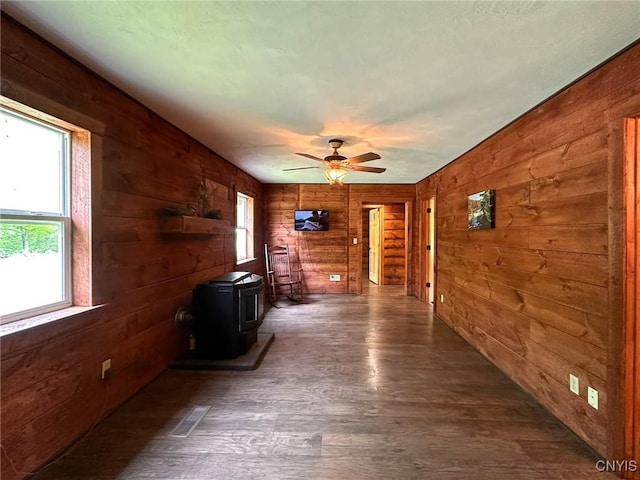 3742 State Route 8, Ohio, NY 13324 - unfurnished living room with a wood stove, wood walls, dark wood-style floors, and ceiling fan