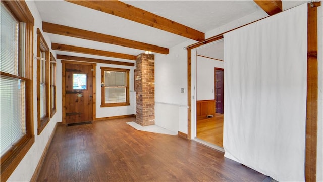 foyer entrance with ornate columns, beam ceiling, wood finished floors, wainscoting, and wooden walls