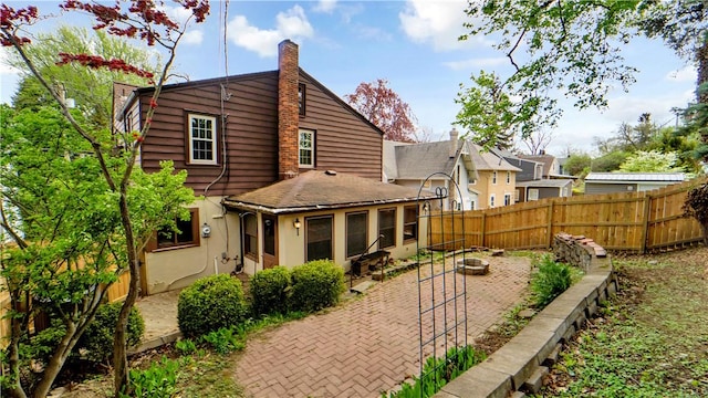 rear view of property with a patio and a chimney