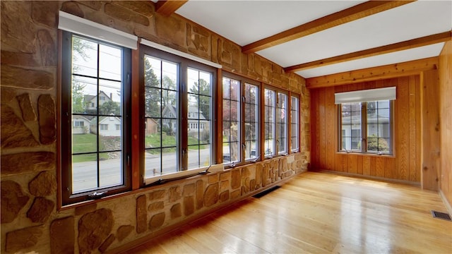 unfurnished sunroom with plenty of natural light and beam ceiling