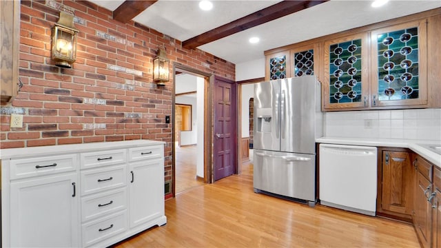 kitchen featuring stainless steel fridge with ice dispenser, white dishwasher, light wood-style floors, light countertops, and white cabinetry