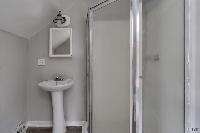 124 Haven St, Watertown-City, NY 13601 - bathroom with a stall shower, baseboard heating, vaulted ceiling, a sink, and baseboards