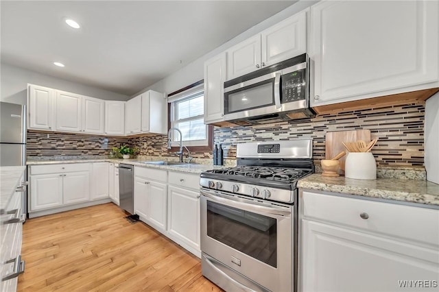 397 14th St, Buffalo, NY 14213 - kitchen with appliances with stainless steel finishes, a sink, white cabinets, backsplash, and recessed lighting