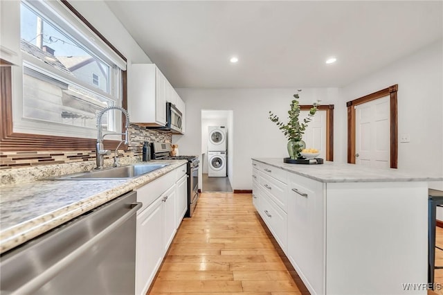 397 14th St, Buffalo, NY 14213 - kitchen with stainless steel appliances, a sink, estacked washer and dryer, tasteful backsplash, and recessed lighting