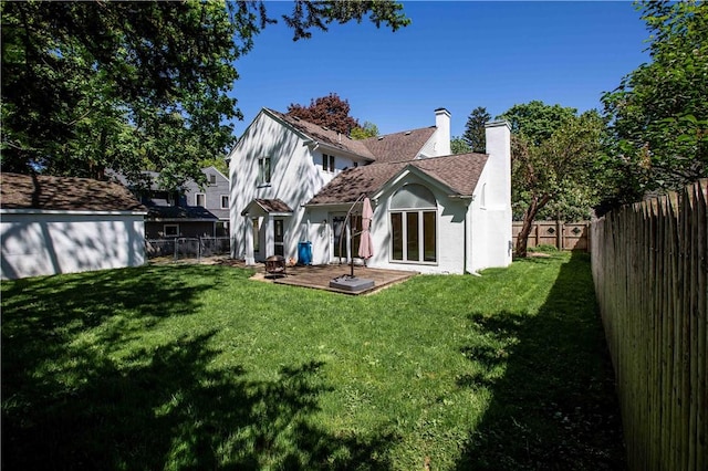rear view of house with a chimney, a patio area, and stucco siding