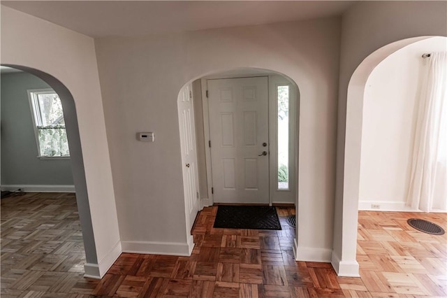 entryway with baseboards and arched walkways
