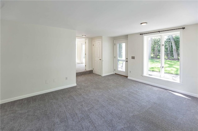 carpeted empty room featuring baseboards