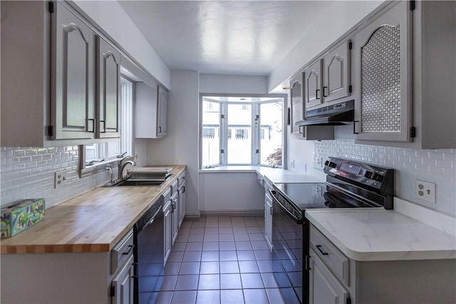 kitchen featuring black / electric stove, a sink, dishwashing machine, under cabinet range hood, and decorative backsplash